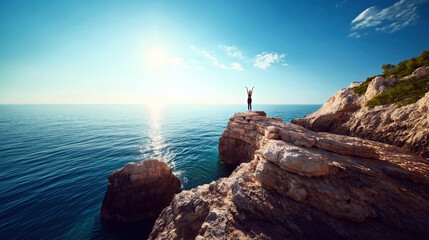 Poster - Person standing on a rocky cliff with arms raised, overlooking a calm sea under a clear sky with the sun shining brightly.