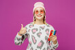 © ViDi Studio - Young fun satisfied happy lesbian woman wear pink animal clothes hold in hand use mobile cell phone show thumb up isolated on plain purple background studio. Pride day June month love LGBTQ concept.