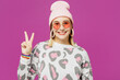 © ViDi Studio - Young smiling happy cheerful fun trendy happy lesbian woman wear pink animal clothes showing victory sign isolated on plain purple background studio portrait. Pride day June month love LGBTQ concept.
