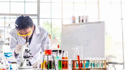 Wall Mural - attractive young asian scientist man lab technician assistant analyzing sample in test tube at labor