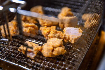 crispy fried chicken cook fry in hot yellow oil in pan for special snack menu in dinner meal at kitchen of restaurant