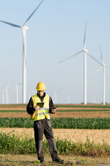 Poster - Engineer with digital tablet works on a field of wind turbines