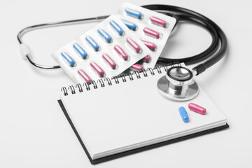 stethoscope equipment and psychotherapy pills modern capsule pink and blue healthy on notebook