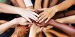 © Supremetones - Close-up of diverse female hands piled together in unity