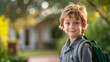 © aciddreamStudio - young 7 years old caucasian boy smiling to camera wearing his backpack ready for the first school day