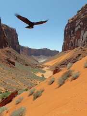 Canvas Print - Majestic Eagle Soaring Over Red Sand Desert Canyon with Rugged Cliffs and Bushes Under Clear Blue Sky