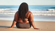© Bill - Big woman with dark hair, back view, on a beach.