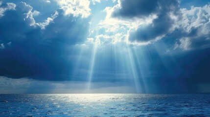 Wall Mural - Light rays shining through clouds above the ocean