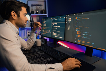 Working smart IT developer analyzing data software development on two pc screen, creating application program updated version online website page system online at neon light cyber office. Surmise.
