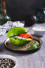 Wall Mural - Keto burger made from avocado, yogurt, red fish and radish on a plate on the table vertical view