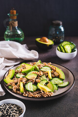 Poster - Delicious salad of buckwheat pasta, cucumber and avocado on a plate vertical view