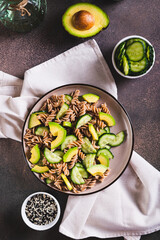 Poster - Gluten free buckwheat pasta, cucumber and avocado on a plate on the table top and vertical view