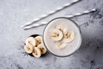 Wall Mural - Banana milkshake with banana slices in a glass