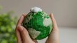 © Togrul - Hand holding green globe with map and have CO2 white cloud on top. Reduce CO2 emissions to limit climate change and global warming. Clean and friendly environment. World sustainable environment.