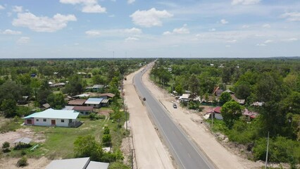 Wall Mural - Aerial view of construction tractor car, bulldozer, or backhoe digging road or street in traffic transportation and agriculture concept. Engine working in urban city town.