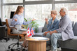 © Pixel-Shot - Female travel agent with mature couple discussing trip in office