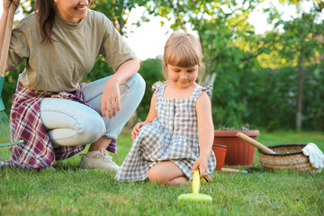 Wall Mural - Mother and her daughter working together in garden