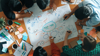 Group of business people writing and making mind map to brainstorming marketing idea at meeting. Top aerial view of investors sharing plan or strategy by using sticky notes. Top view. Convocation.