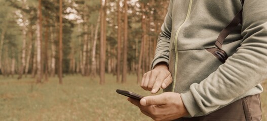 Wall Mural - Person using mobile phone in forest 