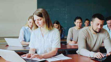 Sticker - Asian and caucasian women university students sitting at table during lesson.