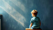 © bit24 - Little Boy autistic sitting in a class on blue wall background. Copy space