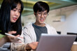 © bongkarn - Two young Asian college student friends are working on a co-project together at a cafe.