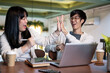 © bongkarn - A cheerful Asian male college student is giving a high five to his friend and celebrating good news.