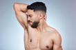 © peopleimages.com - Man, armpit and bad smell for hygiene with sweat problem and body odor for deodorant fail in studio. Model guy, underarm check and frustrated for bacteria and hyperhidrosis crisis by gray background