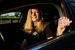 © Lazy_Bear - Happy woman holding driver license in car. First time driving car after exam in driving school