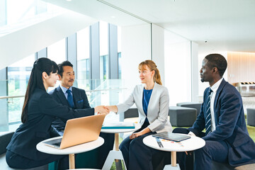 Group of multinational business people shaking hands in a lobby