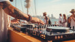 © daniil - DJ mixing music on console mixer board at a luxury yacht party or at a beach party at sea, close-up of dj hands