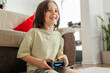 © Westend61 - Smiling boy sitting and playing video game at home