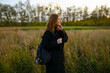 © Westend61 - Thoughtful woman with backpack and standing amidst agricultural field