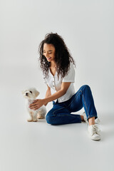 Wall Mural - A young woman tenderly pets her small white Bichon Frise dog.