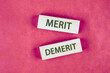 © Ihar - Business and demerit or merit concept. Copy space. Concept word Demerit or Merit on blocks made of wood, top view Conceptual photo
