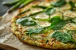 © Mitya - Vegetarian green pizza with cauliflower crust topped with spinach, zucchini, and asparagus
