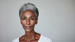 © garpinina - Beautiful senior woman with grey hair  is posing on grey background in a studio - beauty shot