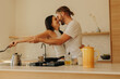 © Jacob Lund - Playful young couple cooking together in a modern kitchen