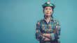 © Bonsales - Female miner wearing helmet with headlamp and plaid shirt standing against blue background. Determined expression and crossed arms indicate confidence and strength