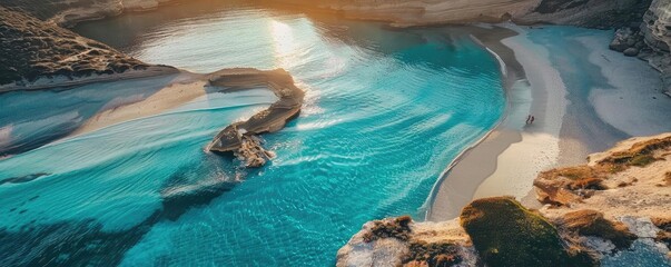 Wall Mural - Stunning aerial view of a pristine turquoise coastal bay with sandy beaches and rocky formations under a golden sunset.
