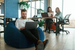 © standret - Career growth. Using laptops. People are working in the office with bean bags chairs in it