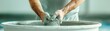 © PTC_KICKCAT - Close-up of hands molding clay in a pottery workshop. Creative process of shaping ceramic material, emphasizing craftsmanship and artistic skill.