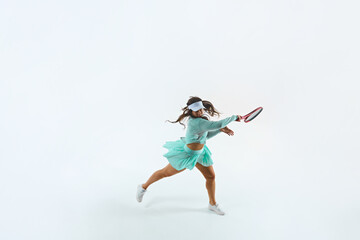 Athletic female tennis player in mint-green outfit performs forehand swing against white studio background. Concept of professional sport, championship, active lifestyle, tournament. Ad