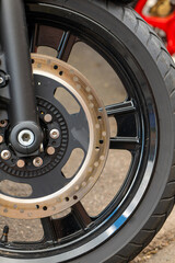 black motorcycle wheel with a black rim and a silver hubcap