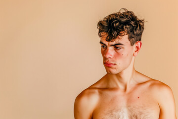 Sad bare-chested man on a beige background