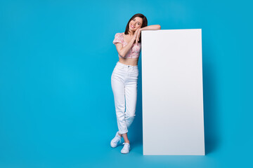Wall Mural - Photo of cute nice pretty lady stylish clothes hand hold big placard banner demonstrate empty space isolated on blue color background