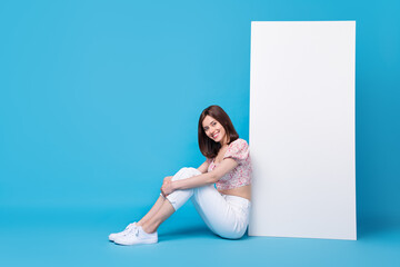 Wall Mural - photo of pretty positive lady sit big telephone board empty space demonstrates modern gadget shop sa