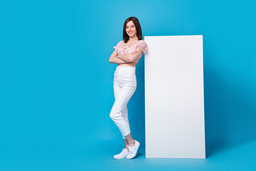 Wall Mural - Photo of charming pretty lady stylish clothes arm folded stand big telephone wall panel empty blank space isolated on blue color background