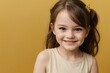 © PNG&Background Image - Happy little girl in casual dress smiling against a yellow background with copy space.