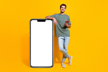 Sticker - Full length photo of cool positive man dressed khaki t-shirt typing messages modern gadget empty space isolated yellow color background